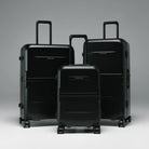 Stacked black hard-shell luggage set with telescopic handles and spinner wheels