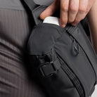 Close-up of charcoal sling bag strap buckle and zip pocket