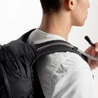 Dark gray backpack side with routed hydration hose and adjustable shoulder strap