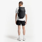 Dark gray backpack worn from behind with mesh back panel and adjustable shoulder straps