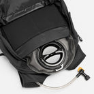 Dark gray backpack interior showing padded sleeve and hydration hose access opening