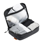 Open black packing cube with mesh-lined zip compartments and socks inside